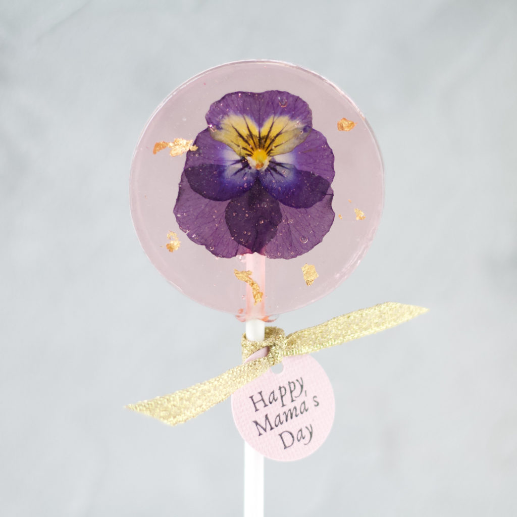 Custom-made lollipop with edible flower and tags